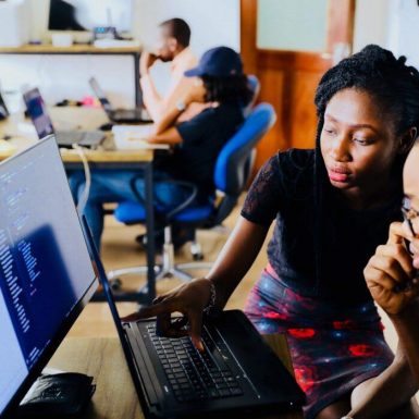 A student and mentor look at a computer screen