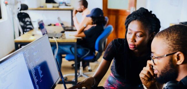 A student and mentor look at a computer screen