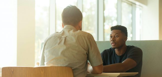 Two people in a booth talking