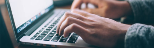 hands typing on a laptop