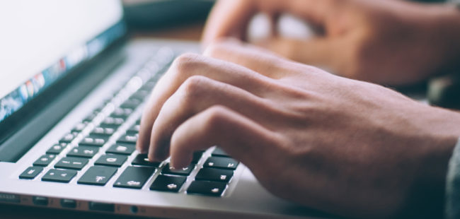 hands typing on a laptop