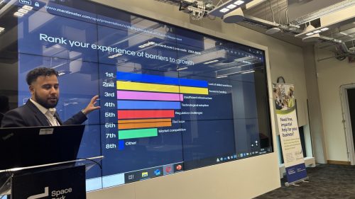 LLBSP Hosts Successful Industrial Strategy Consultation. A person standing in front of a screen showing a bar chart.