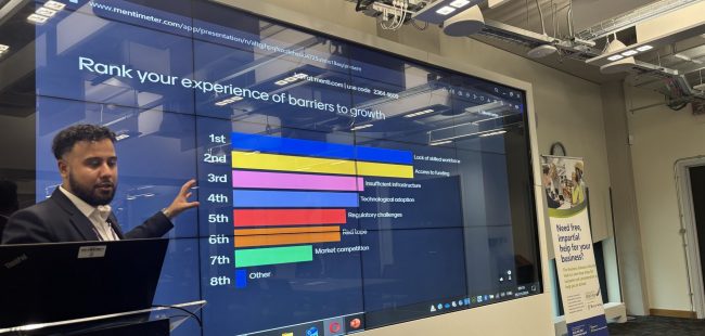 LLBSP Hosts Successful Industrial Strategy Consultation. A person standing in front of a screen showing a bar chart.